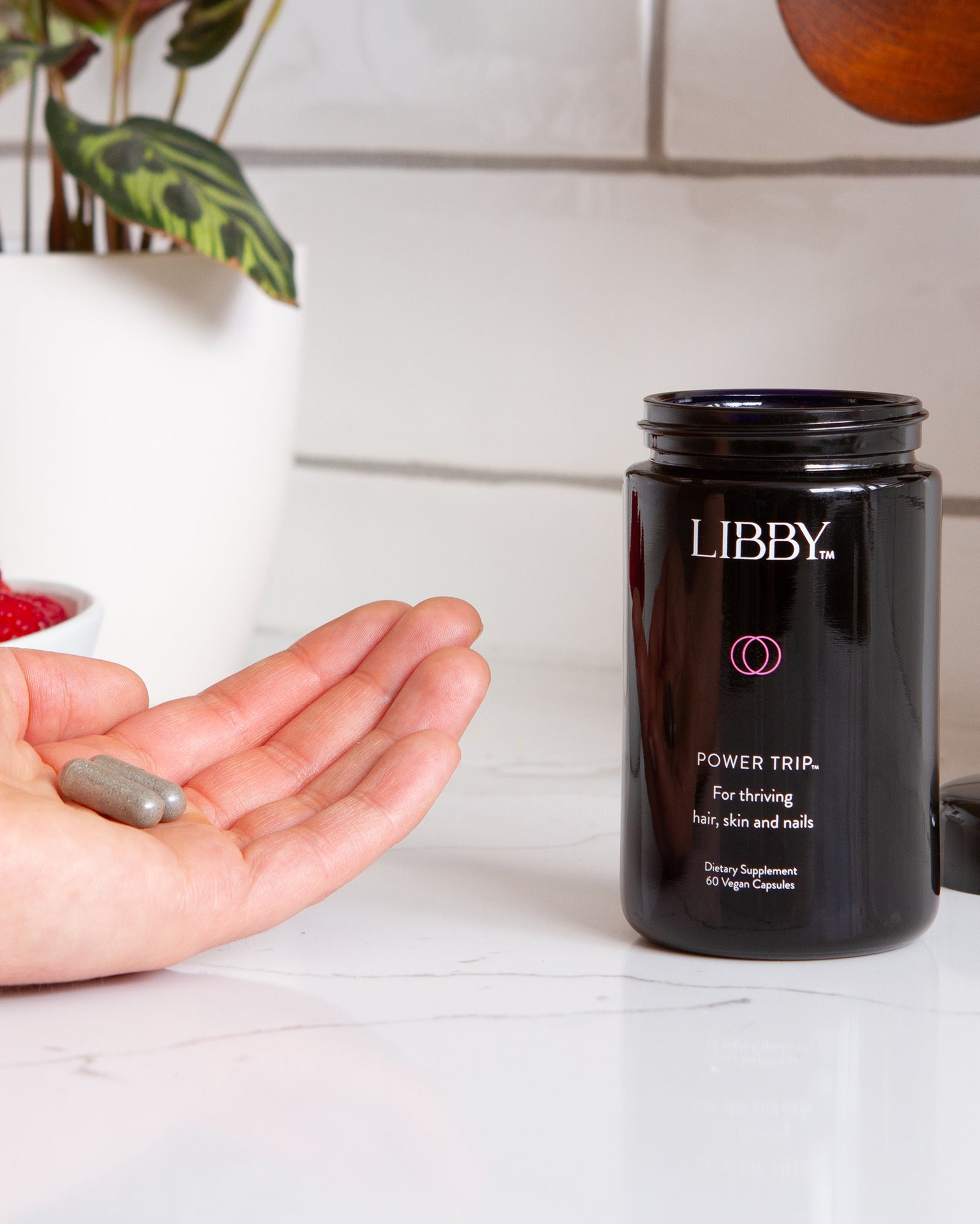 Power Trip supplement black bottle and hand holding supplement